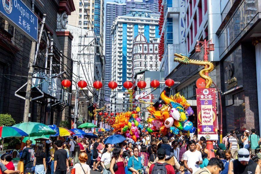Crowds filling Ongpin Street in Binondo, Manila, beneath red Chinese lanterns and colourful decorations