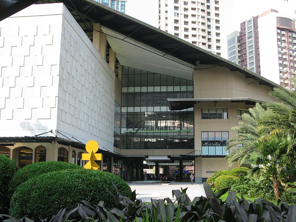 Main entrance to Greenbelt shopping mall in Makati, Manila, with landscaped greenery and modern buildings