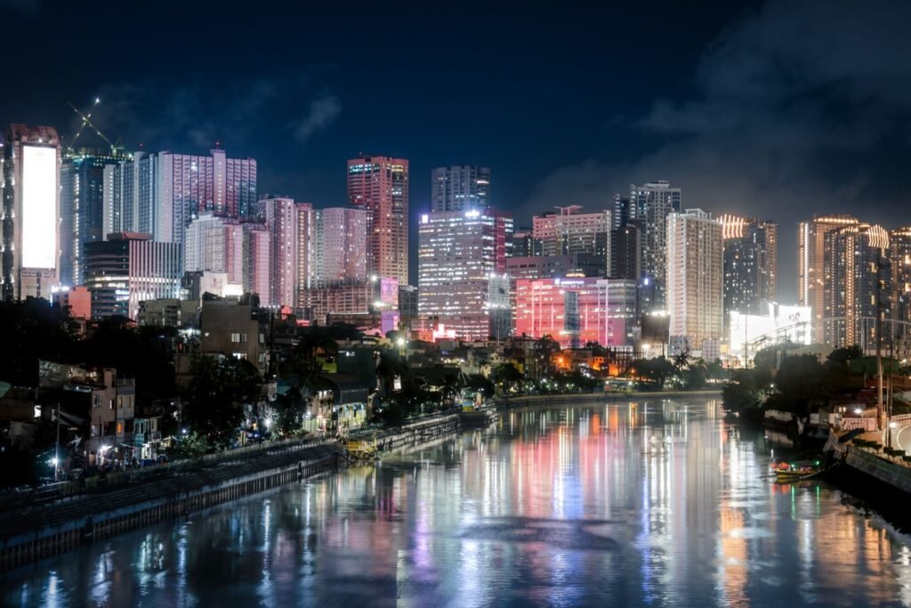 Makati skyline illuminated at night with colorful reflections on the river in Metro Manila