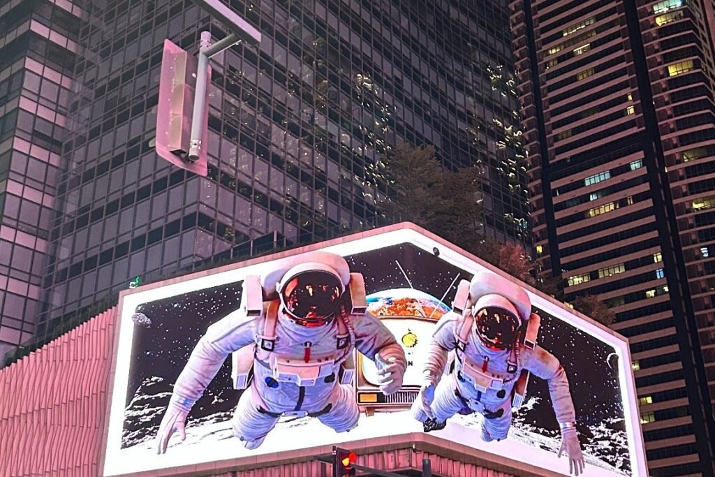 Large illuminated 3D billboard showing two astronauts above a street in Bonifacio Global City, Taguig
