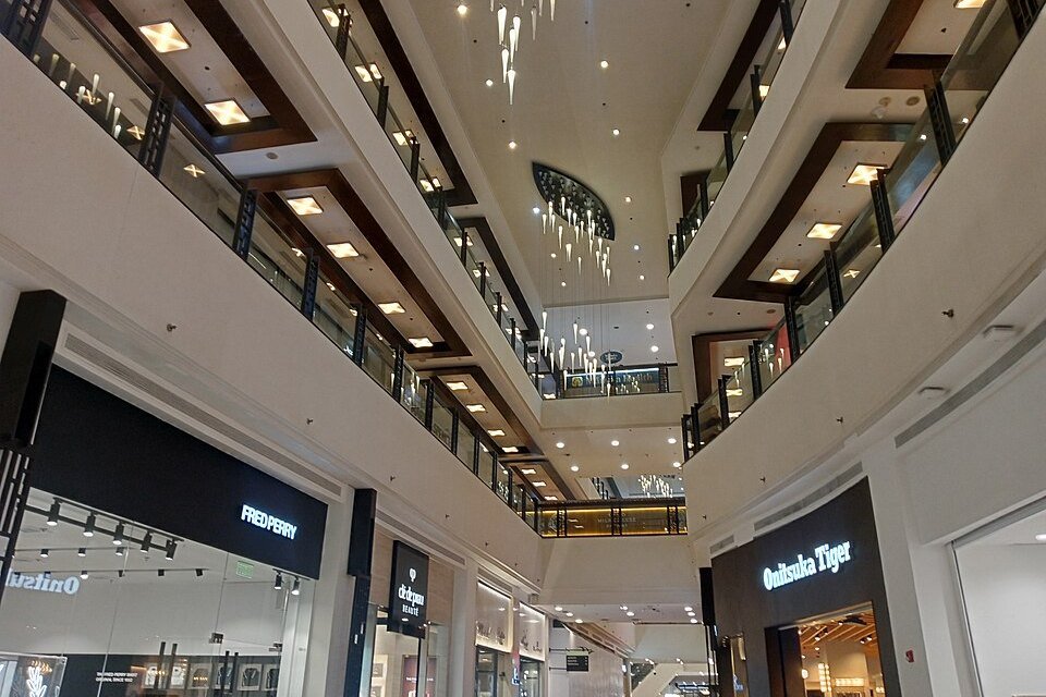 Interior of Greenbelt 5 shopping mall in Makati, Metro Manila with multiple floors, fashion stores, glass railings and ceiling lights