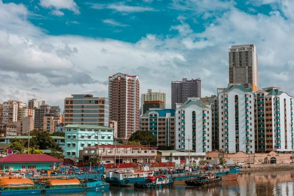 Boats moored along the river in Manila, with residential and high-rise buildings in the background
