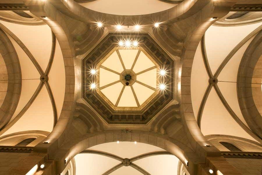 View looking upward at the illuminated octagonal dome and vaulted ceiling inside Manila Cathedral