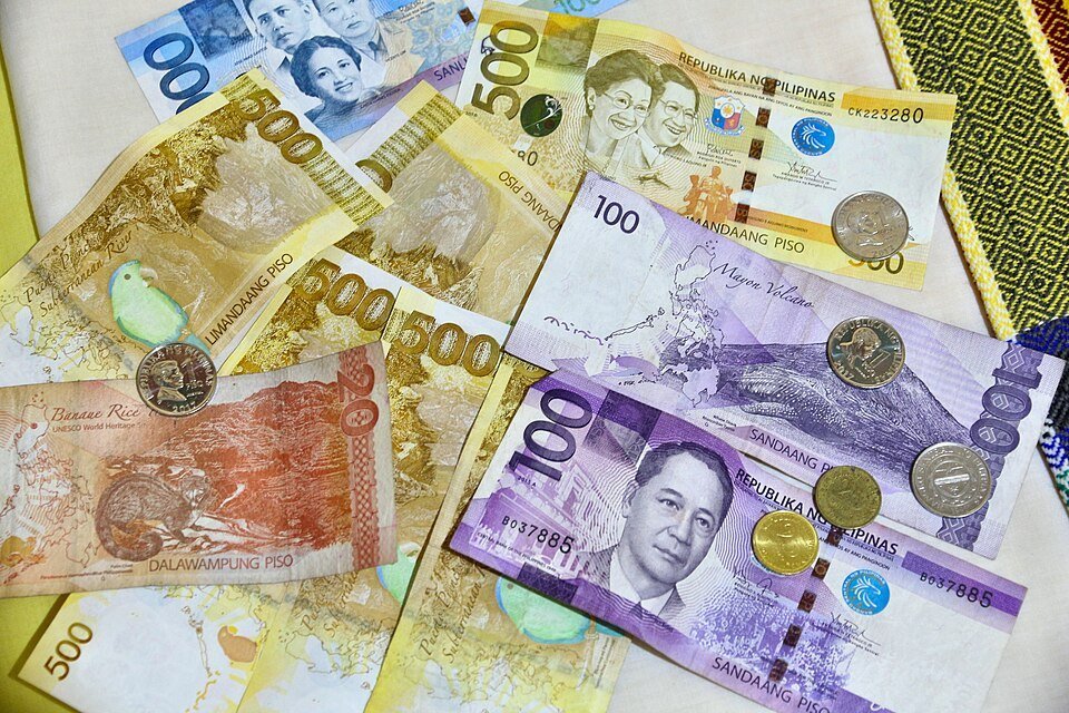 Assorted Philippine peso banknotes and coins, including 20, 100 and 500 peso denominations