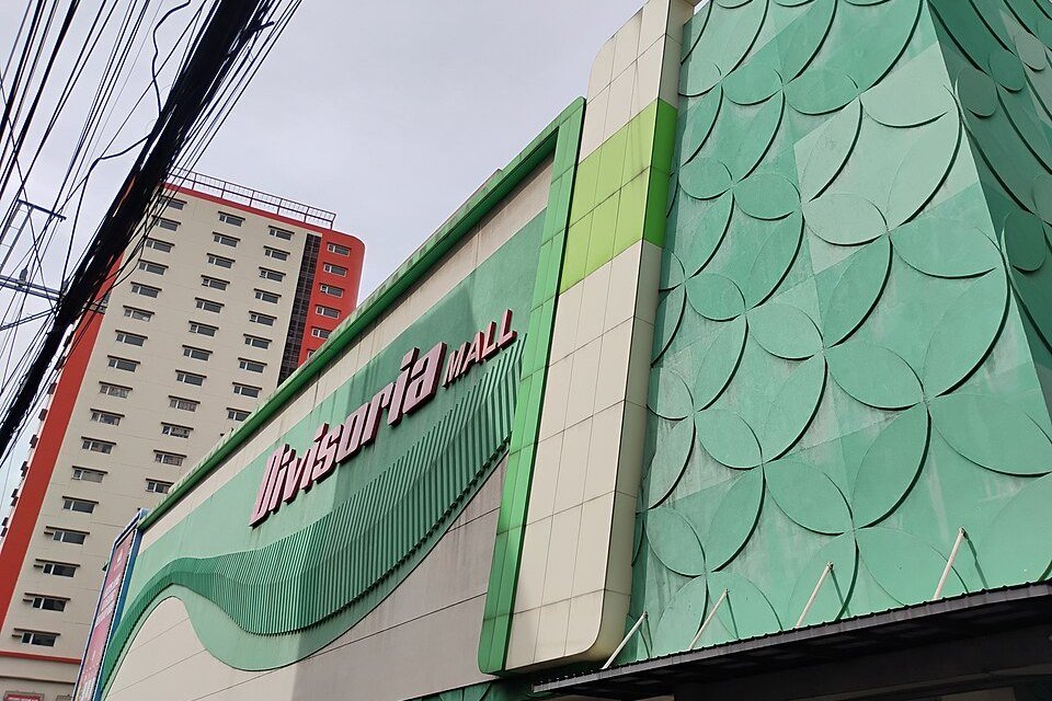 Green and white exterior of Divisoria Mall in San Nicolas, Manila, with its large sign above the street