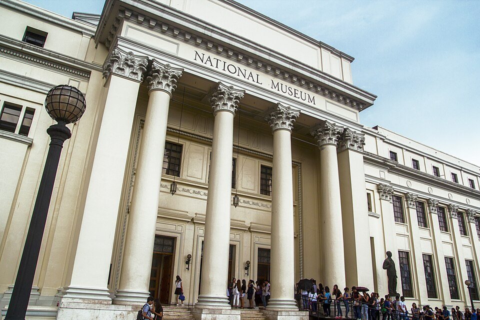 Neoclassical facade of the National Museum of Fine Arts in Manila, with tall columns and visitors near the entrance
