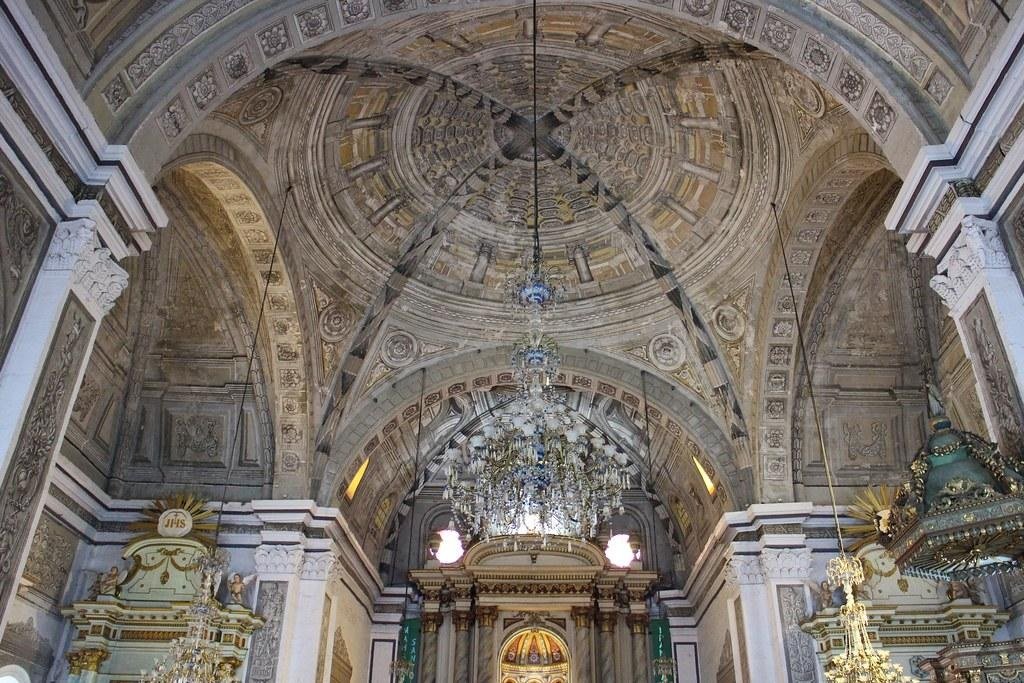 Decorative vaulted ceiling and chandeliers above the main altar inside San Agustin Church in Intramuros