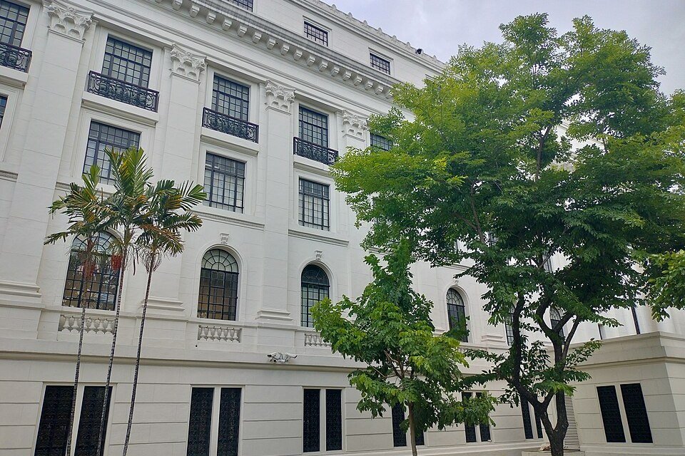 White exterior of the National Museum of Anthropology in Manila, with arched windows and trees in front